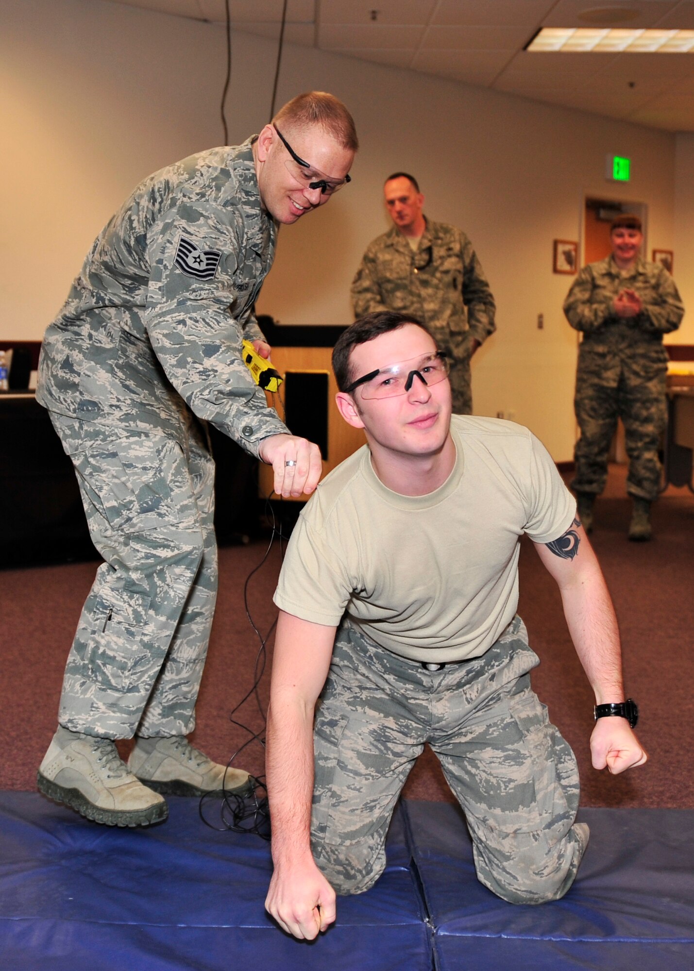 Tech. Sgt. Ryan Overcash, 354th Security Forces Squadron trainer, removes Taser probes from Airman 1st Class Izak Snyder, 354th SFS flight armorer, after a Taser demonstration Oct. 15, 2013, Eielson Air Force Base, Alaska. Over 15 Icemen defenders learned to safely and effectively operate a Taser. (U.S. Air Force photo by Senior Airman Ashley Nicole Taylor/Released)