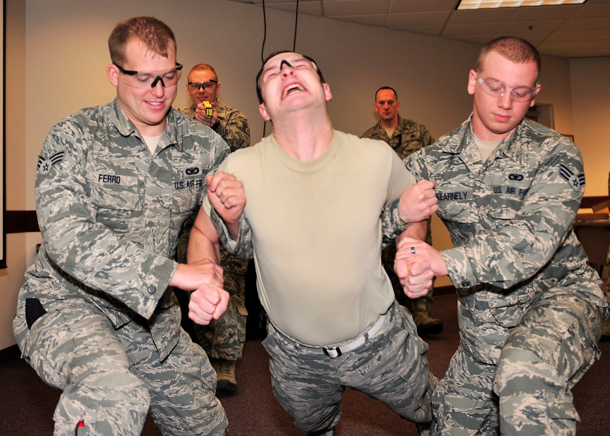 Senior Airmen David Ferro and Sean Kearnely, 354th Security Forces Squadron bravo flight, spots Airman 1st Class Izak Snyder, 354th SFS flight armorer, during annual Taser training Oct. 15, 2013, Eielson Air Force Base, Alaska. Although each Taser has 50,000 volts in a charge, only 1,200 volts are used when it contacts a body. (U.S. Air Force photo by Senior Airman Ashley Nicole Taylor/Released)