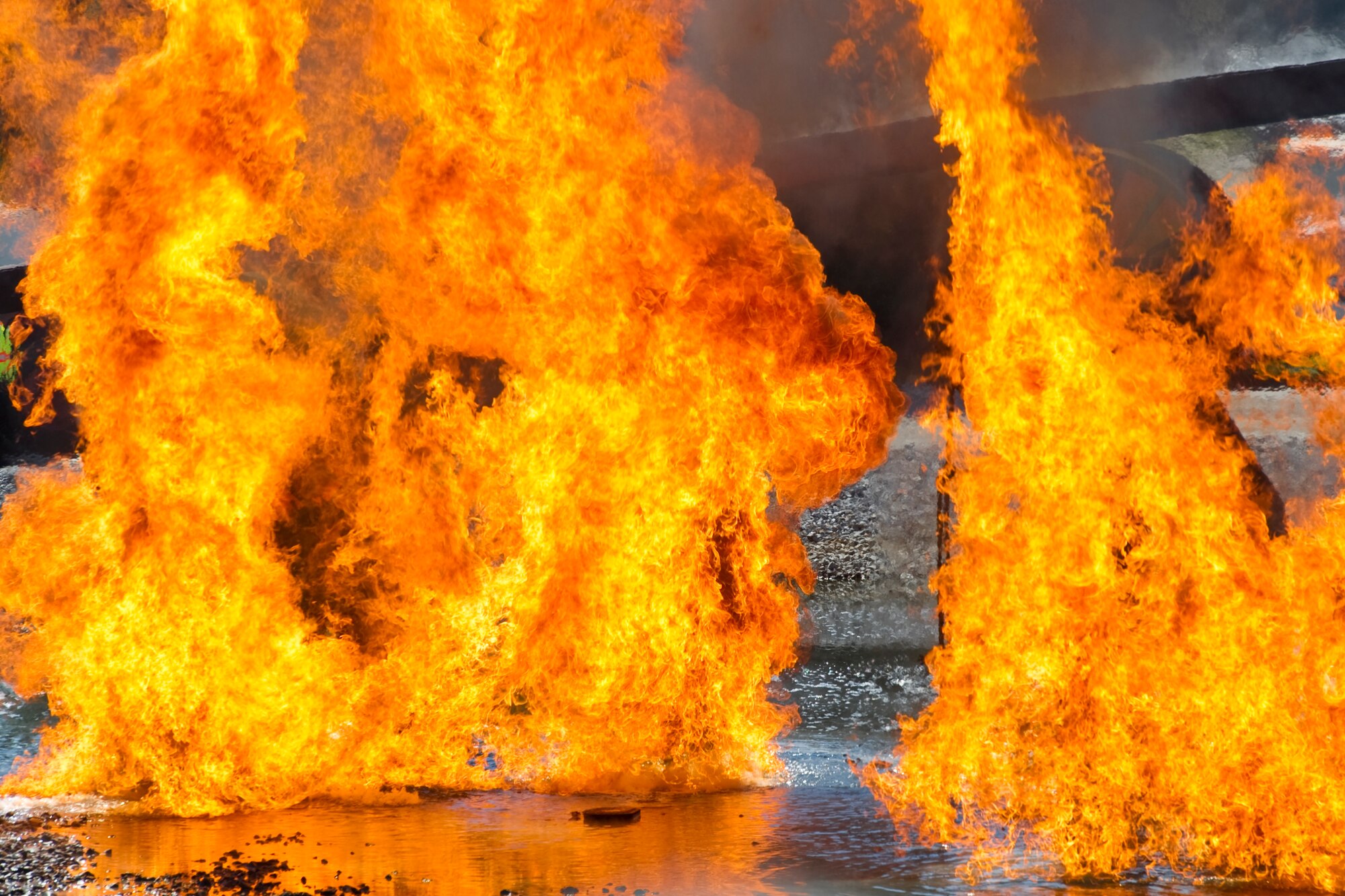 A fire burns around a simulated aircraft during a demonstration for the Fire Prevention Week at Hurlburt Field, Fla., Oct. 10, 2013. The demo served as an opportunity for members of the base to experience a "day in the life" of a Hurlburt Field firefighter during fire prevention week.  (U.S Air Force photo/ Senior Airman Naomi Griego)