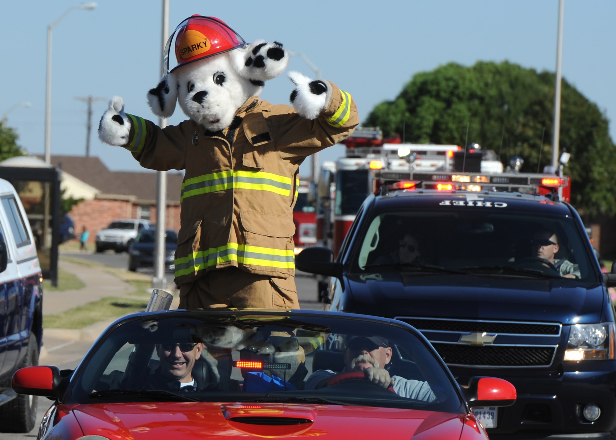 ALTUS AIR FORCE BASE, Okla. – Col. Bill Spangenthal, 97th Air Mobility Wing commander, Billy Allday, 97th Civil Engineer Squadron fire inspector, and Sparky the Fire Dog lead the Fire Prevention Week parade through base housing Oct. 12, 2013. National Fire Prevention Week helps educate families about fire prevention and other hazards by providing training, educational classes and activities. (U.S. Air Force photo by Senior Airman Levin Boland/Released)
