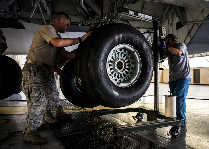 Senior Airman Robert Pearson, 437th Maintenance Squadron crew chief, and Vincent Moseley, 437th MXS aircraft maintainer, remove a worn tire from a C-17 Globemaster III while the aircraft is lifted off the ground by jacks Oct. 7, 2013, at Joint Base Charleston, S.C. A team of eight crew chiefs used six jacks to raise a C-17 Globemaster III off the ground to change a tire and inspect the gears. (U.S. Air Force photo/Senior Airman Dennis Sloan) 

