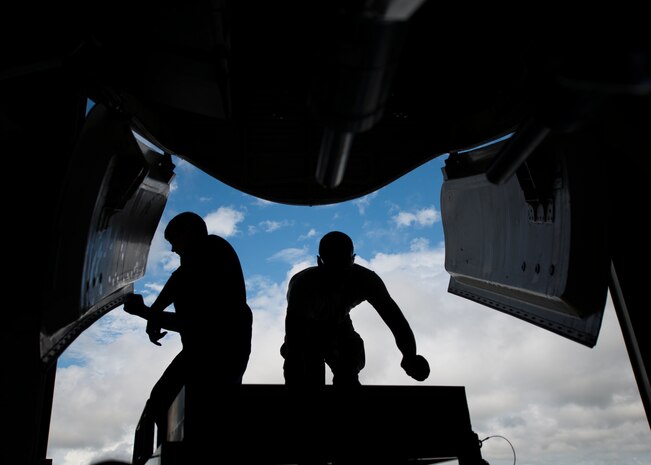 Two 437th Maintenance Squadron crew chiefs work on the front gear of a C-17 Globemaster III while the aircraft is lifted off the ground using jacks Oct. 7, 2013, at Joint Base Charleston, S.C. A team of eight crew chiefs used six jacks to raise a C-17 Globemaster III off the ground to change a tire and inspect the gears. (U.S. Air Force photo/ Senior Airman Dennis Sloan)