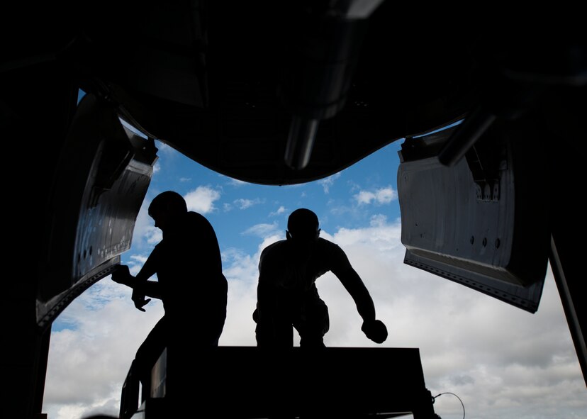 Two 437th Maintenance Squadron crew chiefs work on the front gear of a C-17 Globemaster III while the aircraft is lifted off the ground using jacks Oct. 7, 2013, at Joint Base Charleston, S.C. A team of eight crew chiefs used six jacks to raise a C-17 Globemaster III off the ground to change a tire and inspect the gears. (U.S. Air Force photo/Senior Airman Dennis Sloan) 

