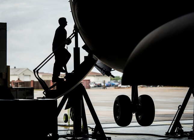 Senior Airman Robert Haberman, 437th Maintenance Squadron crew chief, walks up the stairs of a C-17 Globemaster III while the aircraft is lifted off the ground with jacks Oct. 7, 2013, at Joint Base Charleston, S.C. To raise a C-17 off the ground eight jacks and six crew chiefs are required. (U.S. Air Force photo/ Senior Airman Dennis Sloan)