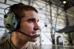 Staff Sgt. Ryan Sova, 437th Maintenance Squadron crew chief, uses a head set to communicate with another Airman in the cockpit while raising a C-17 Globemaster III using jacks Oct. 7, 2013, at Joint Base Charleston, S.C. A team of eight crew chiefs used six jacks to raise a C-17 Globemaster III off the ground to change a tire and inspect the gears. (U.S. Air Force photo/Senior Airman Dennis Sloan) 

