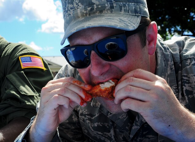 Senior Airman Benny Vickrey, 437th Aircraft Maintenance Squadron instruments and flight control systems technician, eats a hot wing while participating in a hot wing eating contest during the 2013 Oktoberfest Oct. 11, 2013 at Joint Base Charleston - Air Base, S.C. Oktoberfest is an annual event put together by the Top 3 for ranks E-1 through E-6 to show appreciation for their day-to-day hard work. The event included free food and drinks, a disc jockey and a hot wing eating contest. Airmen also played games such as basketball and corn hole. (U.S. Air Force photo/Airman 1st Class Chacarra Neal)