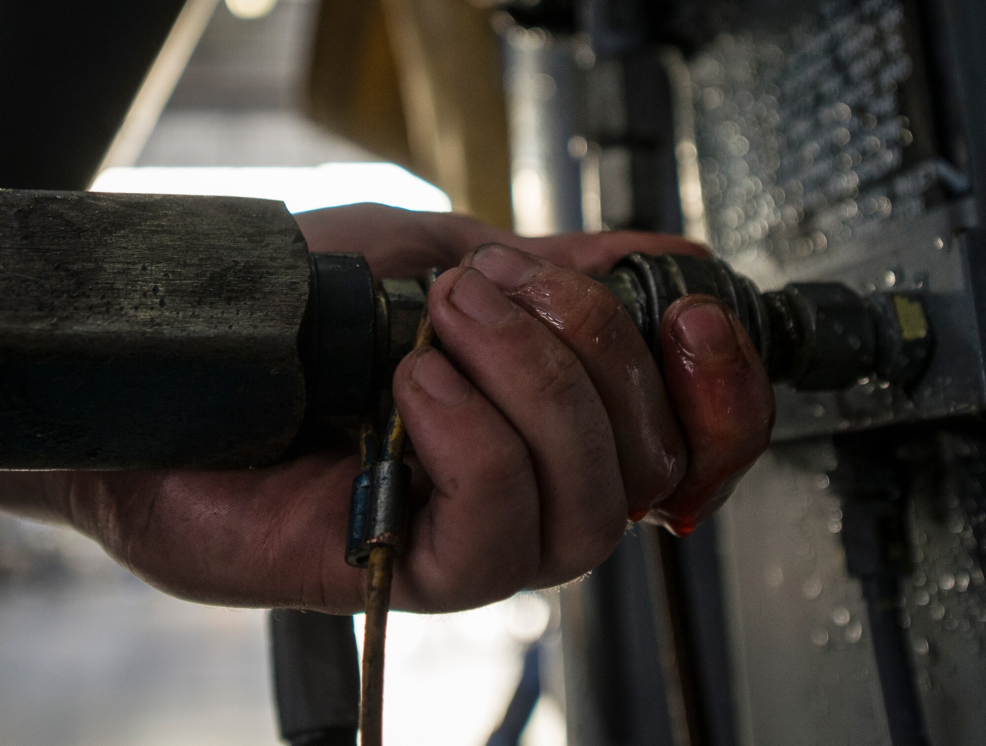 Senior Airman Robert Haberman, 437th Maintenance Squadron crew chief, hooks a hydraulic line to a jack to before using the jacks to raise the C-17 Globemaster III off the ground for a tire change Oct. 7, 2013, at Joint Base Charleston, S.C. To raise a C-17 off the ground eight jacks and six crew chiefs are required. (U.S. Air Force photo/ Senior Airman Dennis Sloan)
