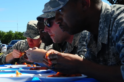 Airmen participate in the hot wing eating contest during the 2013 Oktoberfest Oct. 11, 2013, at Joint Base Charleston - Air Base, S.C. Oktoberfest is an annual event put together by the Top 3 for ranks E-1 through E-6 to show appreciation for their day-to-day hard work. The event included free food and drinks, a disc jockey and a hot wing eating contest. Airmen also played games such as basketball and corn hole. (U.S. Air Force photo/ Airman 1st Class Chacarra Neal)