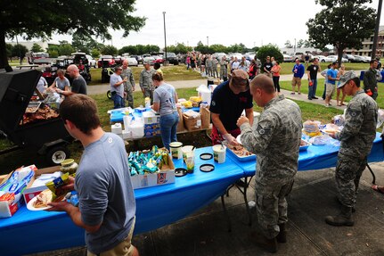 Airmen stand in line to get food served during the 2013 Oktoberfest Oct. 11,2013, at Joint Base Charleston - Air Base, S.C. Oktoberfest is an annual event put together by the Top 3 for ranks E-1 through E-6 to show appreciation for their day-to-day hard work. The event included free food and drinks, a disc jockey and a hot wing eating contest. Airmen also played games such as basketball and corn hole. (U.S. Air Force photo/ Airman 1st Class Chacarra Neal)