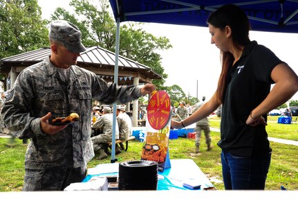 Tech. Sgt. Jeremy Foster, 373rd Training Squadron electrical environmental systems instructor, plays a game at a local vendor during the 2013 Oktoberfest Oct. 11, 2013, at Joint Base Charleston - Air Base, S.C. Oktoberfest was hosted by several local vendors providing food for the event. Oktoberfest is an annual event put together by the Top 3 for ranks E-1 through E-6 to show appreciation for their day-to-day hard work. The event included free food and drinks, a disc jockey and a hot wing eating contest. Airmen also played games such as basketball and corn hole. (U.S. Air Force photo/Airman 1st Class Chacarra Neal)