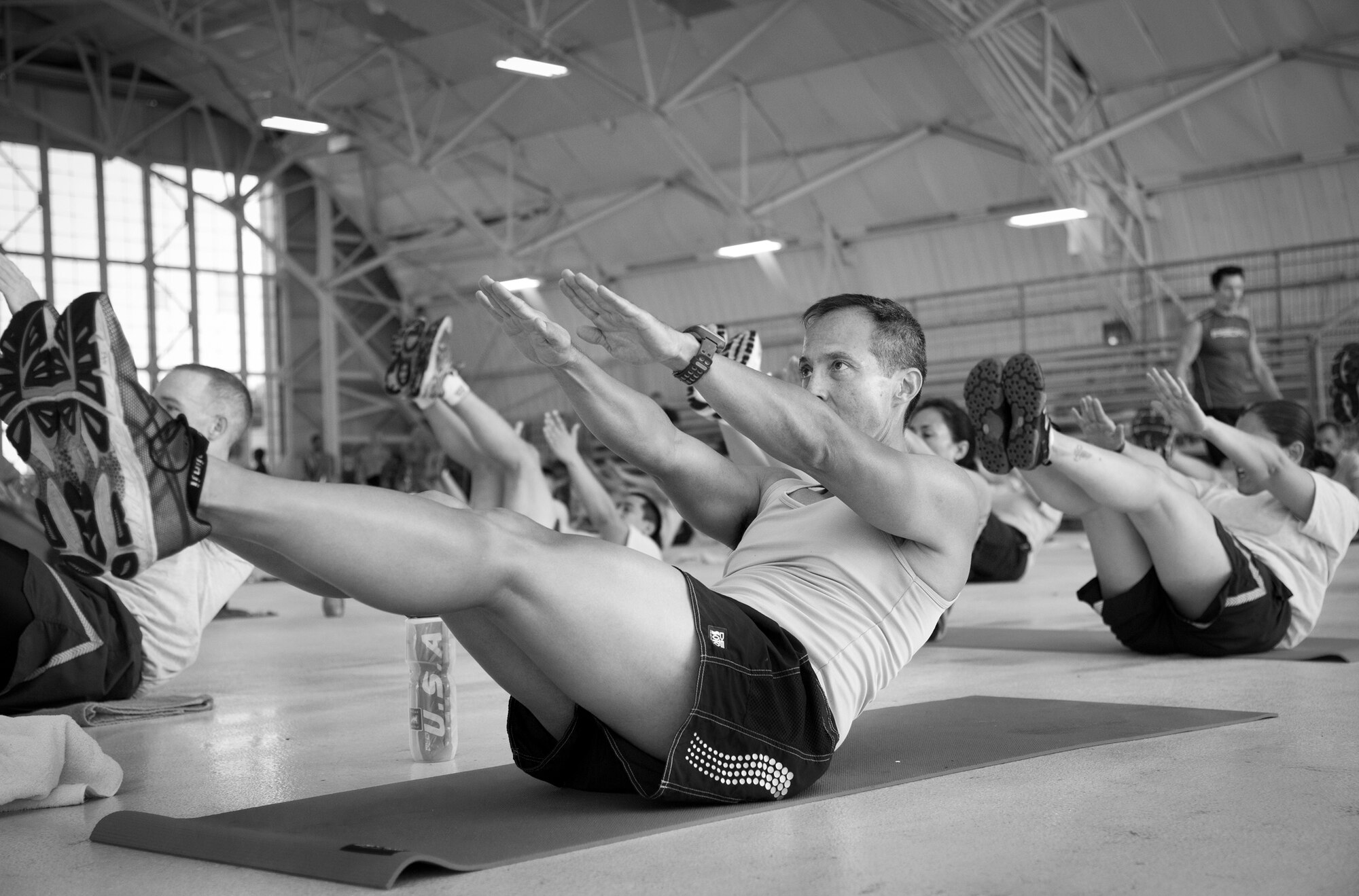Airmen perform a “banana” style crunch with motivation from fitness expert Tony Horton during a 90-minute workout session at Eglin Air Force Base, Fla., Oct. 16.  The workout was part of Horton's day-long visit at Eglin.  Horton also visited Tyndall AFB and Pensacola Naval Air Station  while in the area.  (U.S. Air Force photo/Samuel King Jr.)