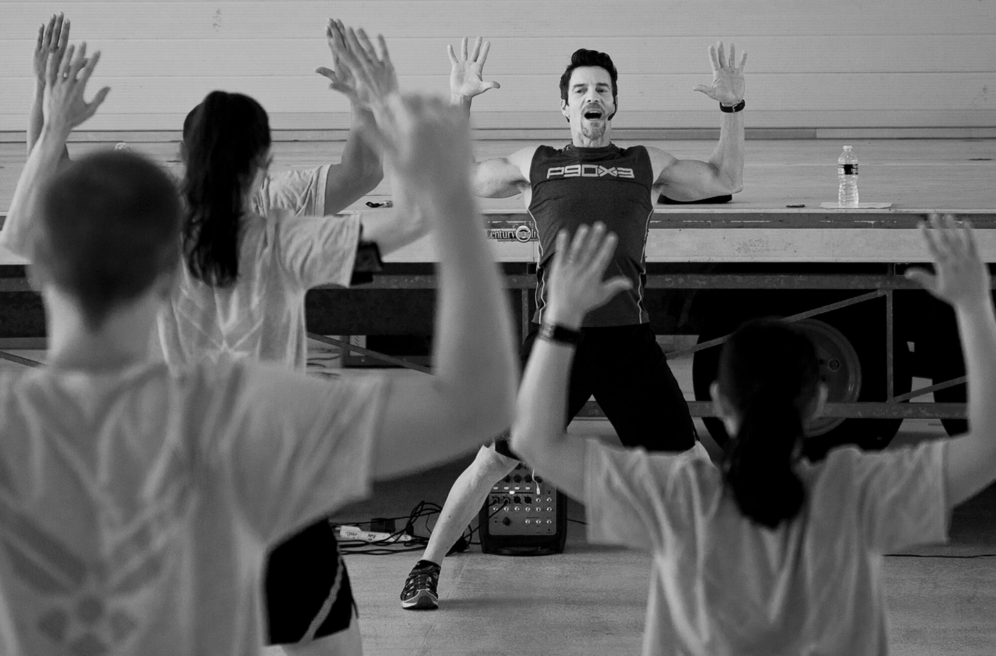 Fitness expert Tony Horton gets Airmen warmed up with some stretches before a 90-minute workout session at Eglin Air Force Base, Fla., Oct. 16.  The workout was part of Horton's day-long visit at Eglin.  Horton also visited Tyndall AFB and Pensacola Naval Air Station while in the area.  (U.S. Air Force photo/Samuel King Jr.)