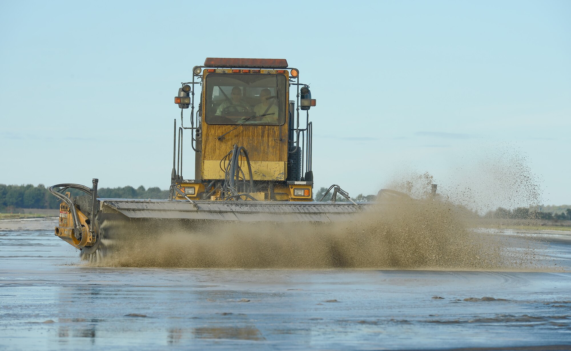 Colonel Rick Moore, 436th Airlift Wing commander, drives an Oshkosh heavy utility tractor Oct. 15, 2013, on Dover's Runway 19 while scrubbing rubber from the landing area of the runway at Dover Air Force Base, Del. Moore and other senior leaders joined members of the 436th Civil Engineer Squadron pavement and heavy equipment operators section, as they removed rubber from Dover's runways. (U.S. Air Force photo/Greg L. Davis)