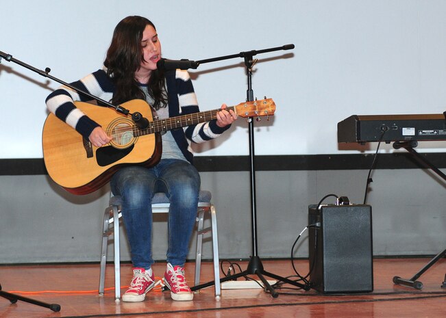 Lisa Alisch plays the guitar and sings during Air Force Sergeants Association Talent Showcase at the Beale Theater, Oct. 11, 2013. Alisch was one of two winners that will move on to perform at Rhythm 105.9 FM’s talent showcase in Yuba City Calif., January 2014. (U.S. Air Force photo by Senior Airman Allen Pollard/Released)