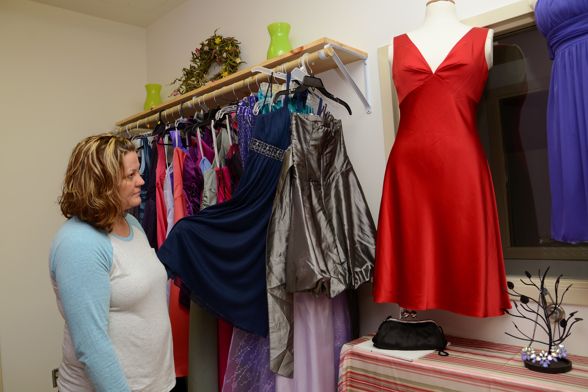 Amye Pederson, Langley Enlisted Spouses Club vice president, shows off the collection of dresses available to members of the military community, their spouses and dependents on Langley Air Force Base, Va., Oct. 16, 2013. The closet offers formal wear and accessories to borrow for special occasions, free of charge, by appointment only.  (U.S. Air Force photo by Airman 1st Class Victoria H. Taylor/Released)