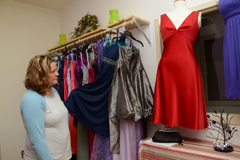 Amye Pederson, Langley Enlisted Spouses Club vice president, shows off the collection of dresses available to members of the military community, their spouses and dependents on Langley Air Force Base, Va., Oct. 16, 2013. The closet offers formal wear and accessories to borrow for special occasions, free of charge, by appointment only.  (U.S. Air Force photo by Airman 1st Class Victoria H. Taylor/Released)