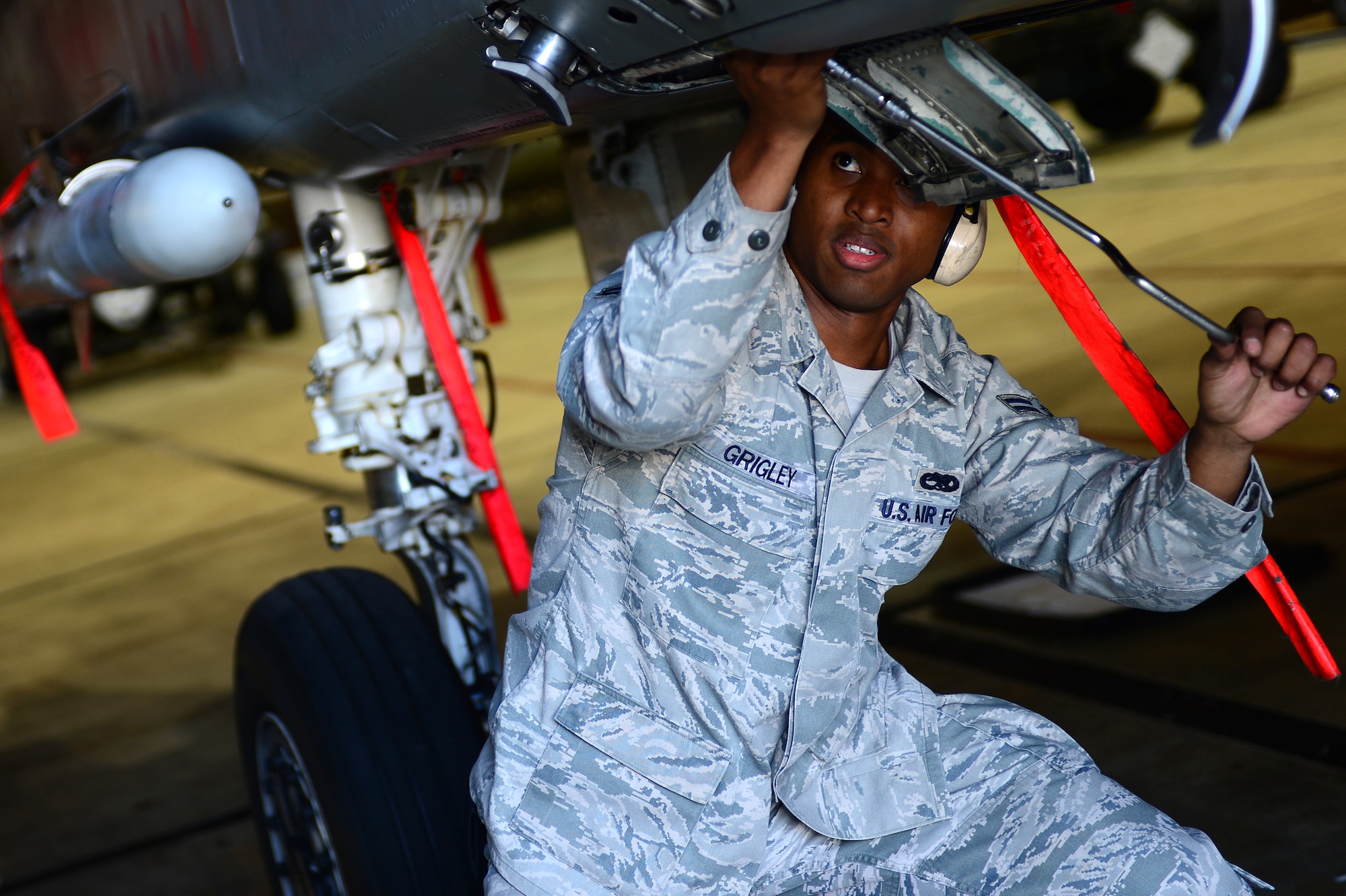 Airman 1st Class Orlando Grigley, 493rd Aircraft Maintenance Unit weapons load crew member, prepares an F-15E Strike Eagle for munitions loading during the Royal Air Force Lakenheath, England, Load Crew of the Quarter competition Oct. 10, 2013. The competition featured the best load crew teams from the 492nd, 493rd, 494th AMUs and 48th Munitions Squadron. The winner was determined by the fastest time loading munitions with the least amount of errors. (U.S. Air Force photo by Airman 1st Class Dana J. Butler/Released) 