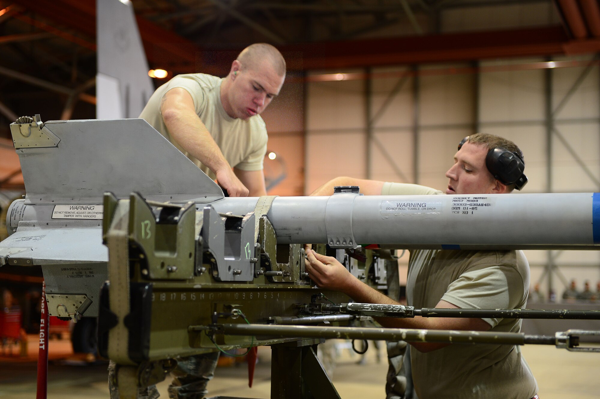 Senior Airman Stefan Naumburger, 494th Aircraft Maintenance Unit weapons load crew member, and Staff Sgt. Frederick Manternach, 494th AMU weapons load crew team chief, prepare to transport an AIM-9 munition during the Royal Air Force Lakenheath, England, Load Crew of the Quarter competition Oct. 10, 2013. The competition featured the best load crew teams from the 492nd, 493rd, 494th AMUs and 48th Munitions Squadron. The winner was determined by the fastest time loading munitions with the least amount of errors. (U.S. Air Force photo by Airman 1st Class Dawn M. Weber/Released) 