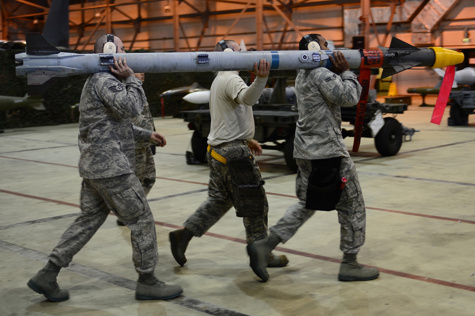 A 493rd Aircraft Maintenance Unit weapons load crew, hand carry an AIM-9 munition during the Royal Air Force Lakenheath, England, Load Crew of the Quarter competition Oct. 10, 2013. The competition featured the best load crew teams from the 492nd, 493rd, 494th AMUs and 48th Munitions Squadron. The winner was determined by the fastest time loading munitions with the least amount of errors. (U.S. Air Force photo by Airman 1st Class Dana J. Butler/Released) 