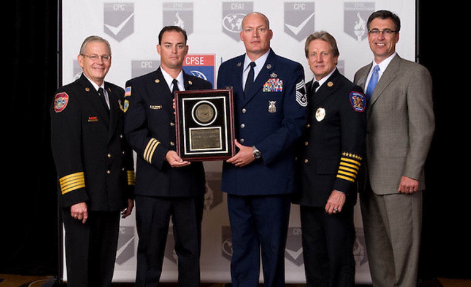 (Left to right) Randy Bruegman, Center for Public Safety Excellence president, Matthew Amann, 6th Civil Engineer Squadron assistant chief of training, Chief Master Sgt. Kevin Riehle, 6th CES fire and emergency services chief, Gary Curmode, CPSE assessor, and Raymond "Allan" Cain, CPSE chairman, pose with a plaque in honor of the MacDill Air Force Base, Fla., fire department obtaining an international accreditation with the Commission of Fire Accreditation International on Aug. 15, 2013. The MacDill fire department was the seventh fire department in the Air Force to receive the accreditation. 
Courtesy photo
