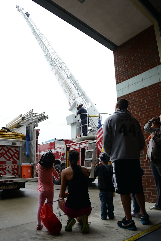 Families in attendance at the Fort Eustis Fire Department open house watch a fire truck ladder demonstration at Fort Eustis, Va., Oct. 12, 2013. The open house is an annual event held to educate families on fire safety. (U.S. Air Force photo by Staff Sgt. Ciara Wymbs/Released)