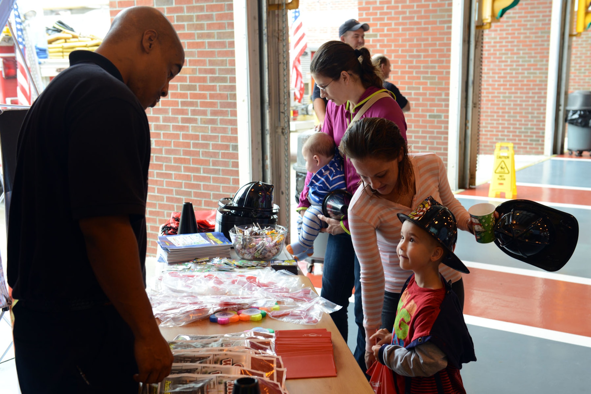 William Roland, 733rd Civil Engineer Division firefighter, speaks to children about fire safety during the fire department open house at Fort Eustis, Va., Oct. 12, 2013. The fire department staff taught children about fire safety, handed out literature and gave a fire-truck tour. (U.S. Air Force photo by Staff Sgt. Ciara Wymbs/Released)