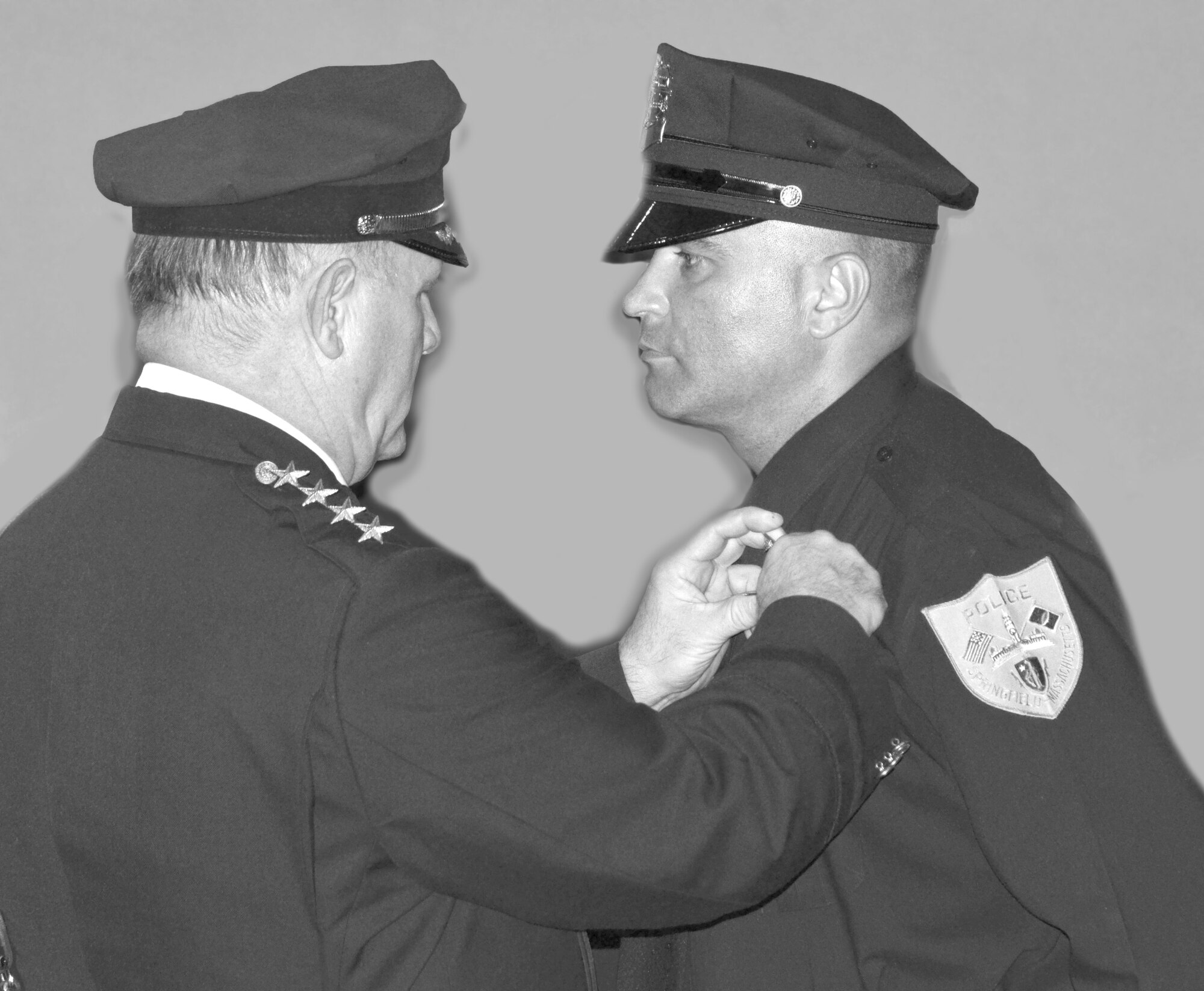Springfield Police Commissioner William Fitchet pins on MSgt. Arjel Falcon’s badge during the Springfield Police Academy graduation Sept. 5. (U.S. Air Force photo/SSgt. Kelly Galloway)