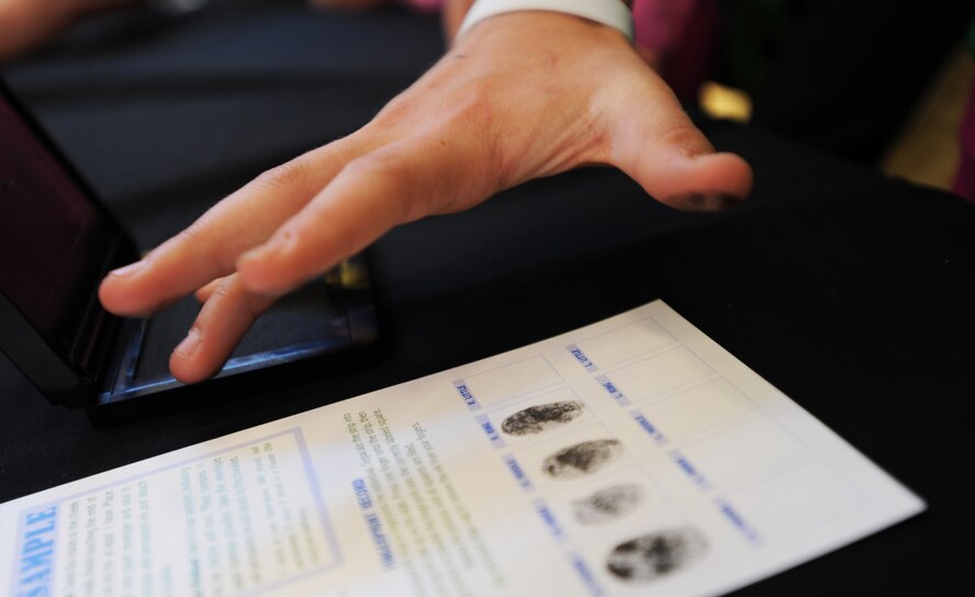 As part of Operation Mugs and Hugs hosted at the Dakota Square Mall in Minot, N.D., Oct. 12, parents had the opportunity to fingerprint and photograph their children for safe-keeping. Airmen from Minot Air Force Base volunteered alongside law enforcement officers and other members from local community organizations to make the event a success. (U.S. Air Force photo/Senior Airman Jose L. Hernandez)