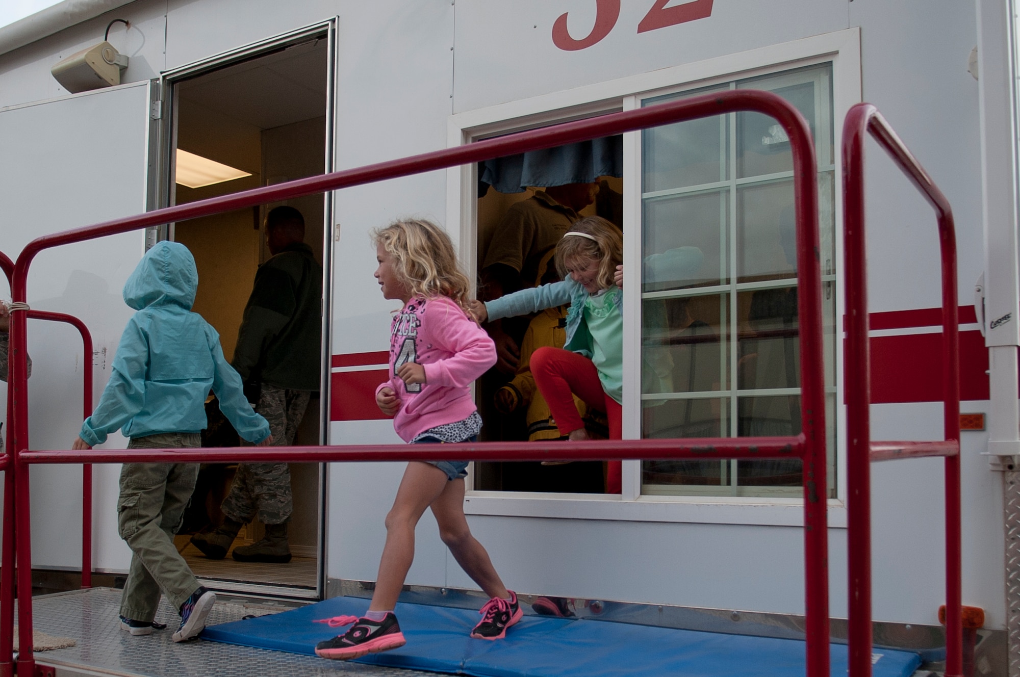 ALTUS AIR FORCE BASE, Okla. – Children from L. Mendel Rivers Elementary School climb out the window of a house fire simulator during house-fire prevention training Oct. 15. The training was a part of Fire Prevention Week and helped children learn the basic steps to take during a house fire. (U.S. Air Force photo by Senior Airman Dillon Davis/Released)