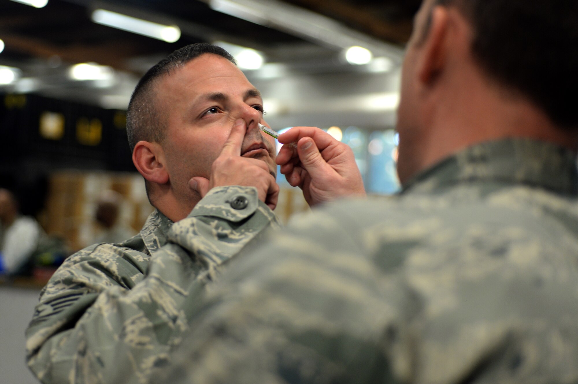 SPANGDAHLEM AIR BASE, Germany—Tech. Sgt. Damian Horton, 52nd Aircraft Maintenance Squadron flightline expediter, from Cooper City, Fla., receives his flu mist injection during a medical exercise Oct. 16, 2013. The 52nd Public Health Emergency Office leveraged the exercise to demonstrate the wing's capability to service the base population in the event of a disease threat or outbreak as efficiently as possible. (U.S. Air Force photo by Senior Airman Alexis Siekert/Released)