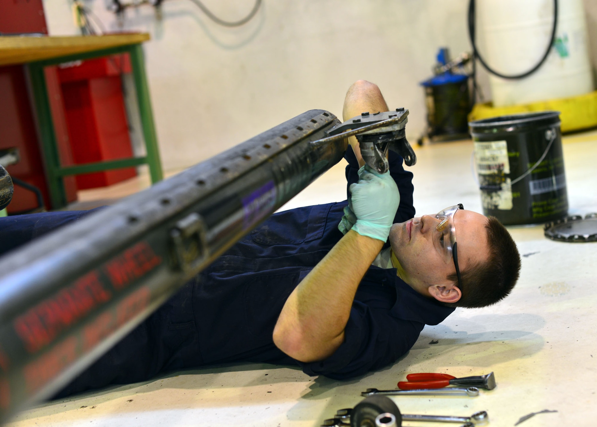 Airman 1st Class Kyle Bathory, 31st Maintenance Squadron aerospace ground equipment journeyman, replaces screws on a dolley, Oct. 10, 2013, at Aviano Air Base, Italy. The AGE shop is split into five sections that work three shifts: dispatch, inspection and repair, bomb lifts and the production support section. (U.S. Air Force photo/Senior Airman Briana Jones)
