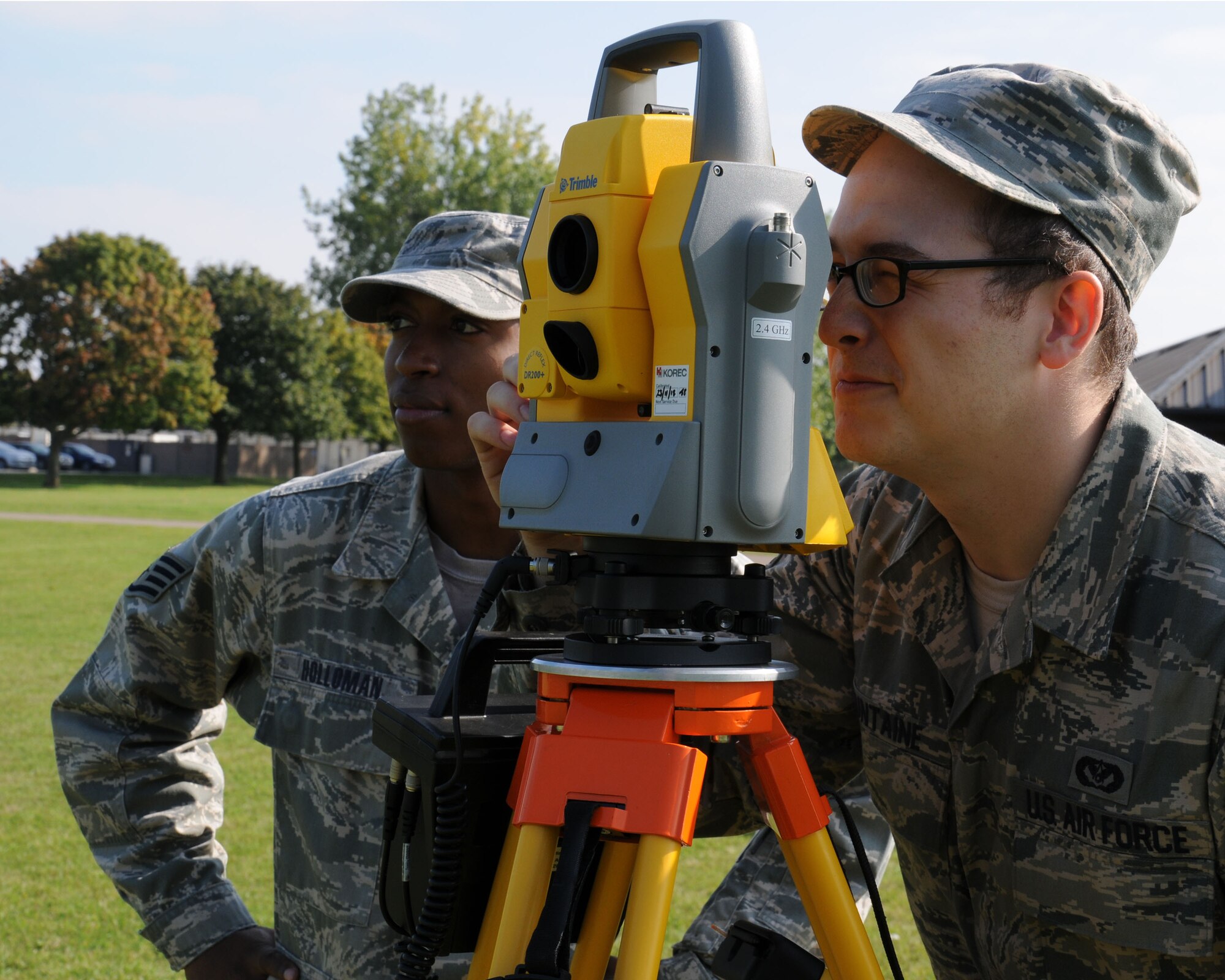 U.S. Air Force Staff Sgt. Erik Holloman, left, 100th Civil Engineer Squadron NCO in charge of geobase from Washington, D.C., trains U.S. Air Force Senior Airman Logan Fountaine, 100th CES engineering journeyman from Ontario, N.Y., on how to use a geodimeter Sept. 27, 2013, on RAF Mildenhall, England. The 100th CES Engineer Assistants shop provides mapping, drafting and surveying support to maintain the installation base map. This support includes drawing and updating individual building floor plans, and ensuring all utilities and infrastructures are geo-referentially located to the exact coordinate system. (U.S. Air Force photo by Gina Randall/Released)