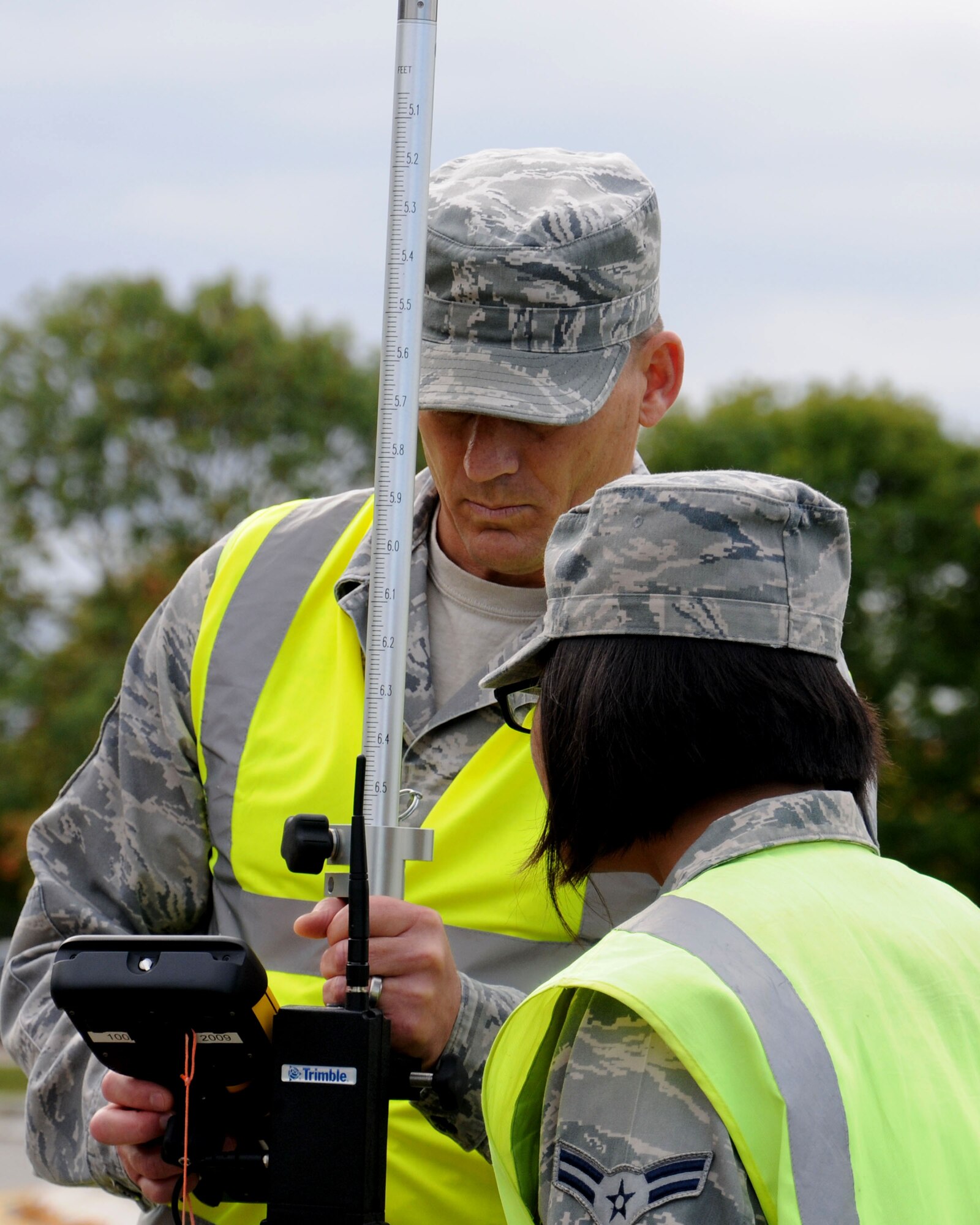 U.S. Air Force Chief Master Sgt. Tracy Jones, left, 100th Air Refueling Wing command chief, uses a geodimeter to map a new parking lot Oct. 9, 2013, on RAF Mildenhall, England. Members of the 100th ARW leadership visited the 100th Civil Engineer Squadron Engineer Assistants shop as part of the “dirty jobs” program. U.S. Air Force Airman 1st Class Abigail Cheek, 100th CES engineering apprentice from Fairfax, Va., explained to Jones how the shop uses 32 satellites in orbit to give the user +/- 2 centimeter precision measurements anywhere on Earth. (U.S. Air Force photo by Gina Randall/Released)