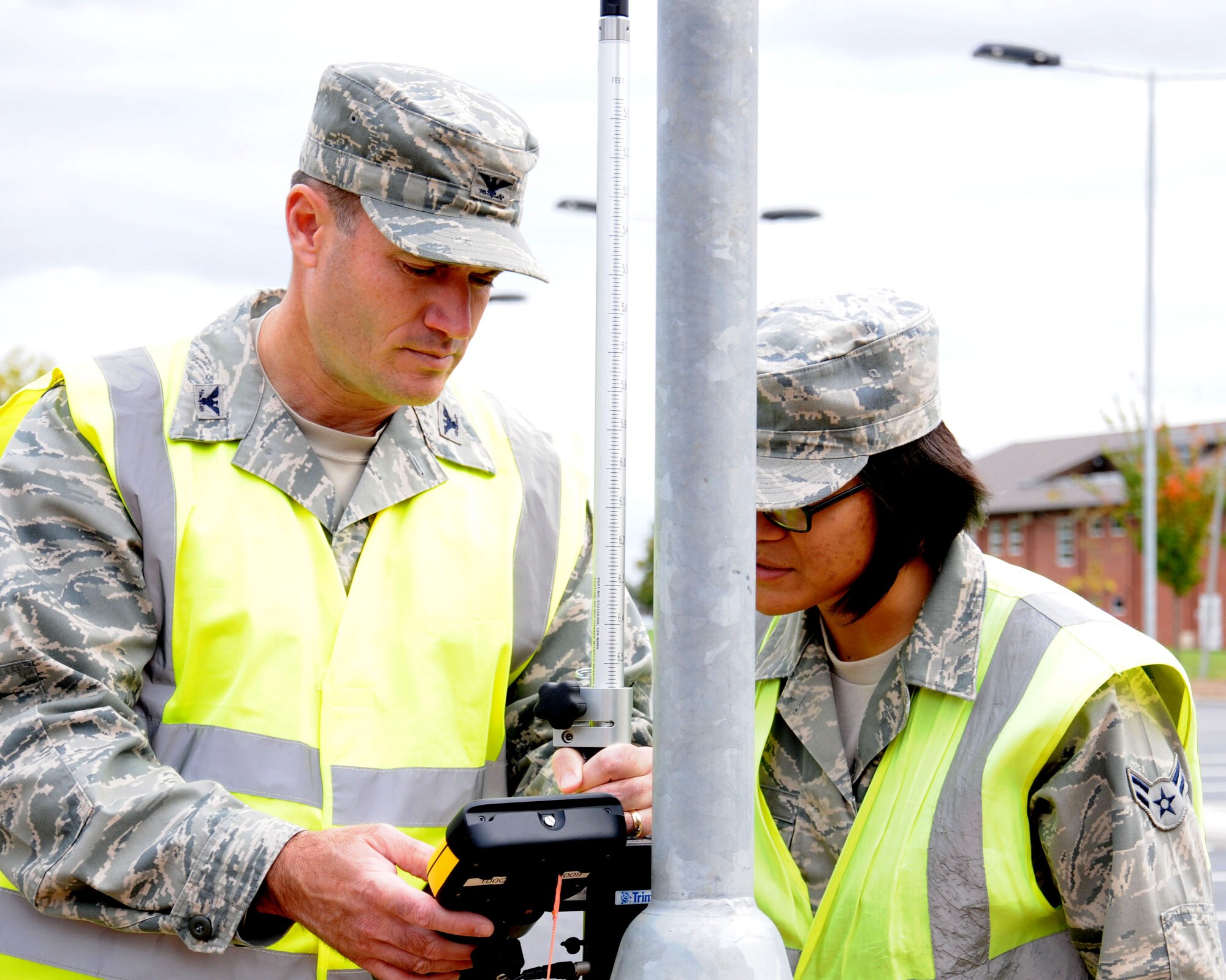 U.S. Air Force Airman 1st Class Abigail Cheek, right, 100th Civil Engineer Squadron engineering apprentice from Fairfax, Va., trains U.S. Air Force Col. Kenneth T. Bibb Jr., 100th Air Refueling Wing commander, how to use a geodimeter Oct. 9, 2013, on RAF Mildenhall, England. Members of the 100th ARW leadership visited the 100th CES Engineer Assistants shop as part of the “dirty jobs” program. Cheek explained how the 100th CES Engineer Assistants shop uses 32 satellites in orbit to give the user +/- 2 centimeter precision measurements anywhere on Earth. (U.S. Air Force photo by Gina Randall/Released)