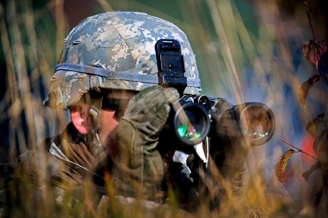 A U.S. soldier uses binoculars to scan the terrain during reconnaissance training at the 7th Army Joint Multinational Training Command's Grafenwoehr Training Area, Germany, Oct. 08, 2013, to prepare for upcoming exercise "Steadfast Jazz" in Poland. The soldier is assigned to the 1st Squadron, 91st Cavalry Regiment, 173rd Infantry Brigade Combat Team.