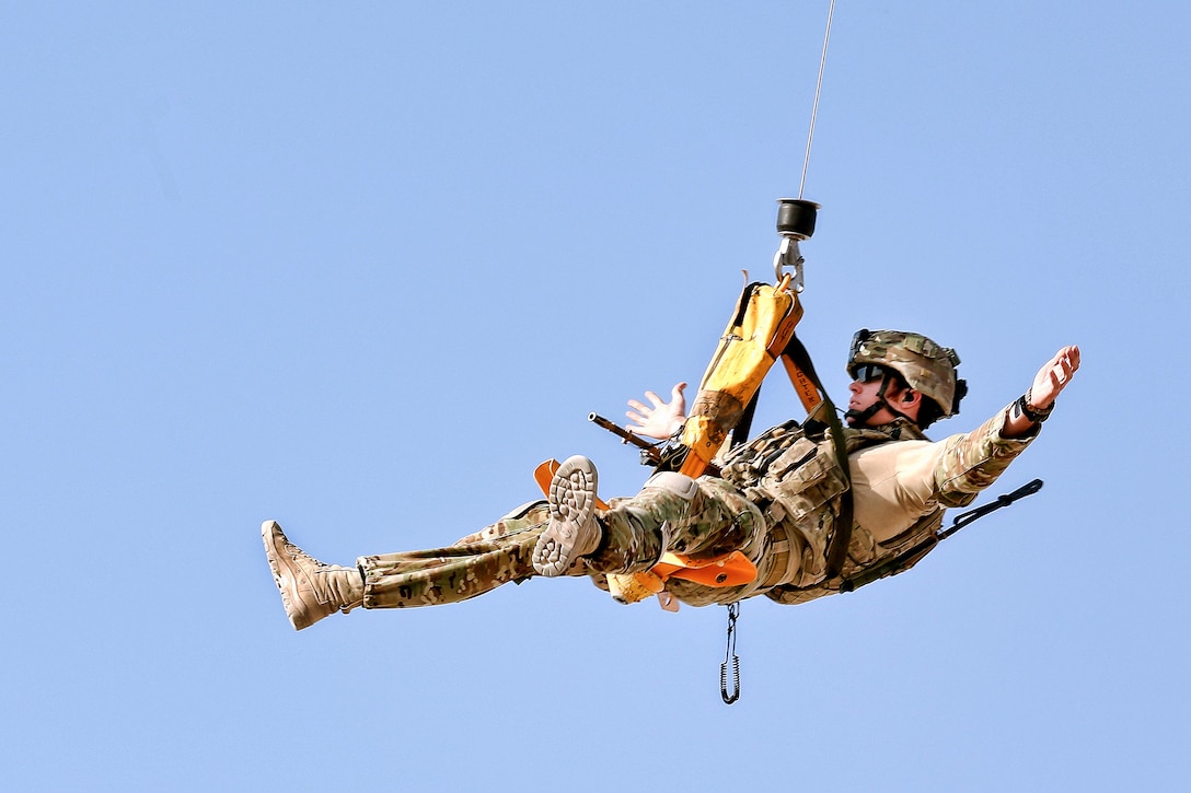 A U.S. Army UH60 Black Hawk helicopter hoists an Australian airman on