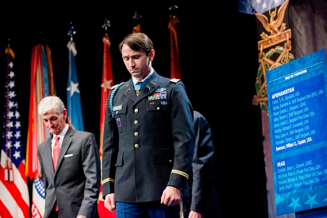 Medal of Honor recipient former Army Capt. William D. Swenson stands as Army Secretary John M. McHugh looks on during the ceremony to induct Swenson into the Hall of Heroes at the Pentagon, Oct. 16, 2013.