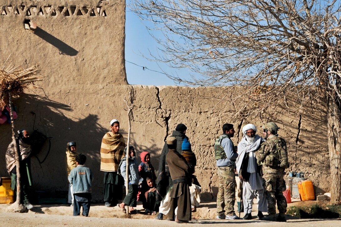 U.S. Navy Petty Officer 1st Class Daniel Baudin, right, talks with an Afghan elder in Bala Boluk, Afghanistan, Jan. 2, 2013. Baudin is an intelligence specialist assigned to Provincial Reconstruction Team Farah, which trains, advises and assists Afghan government leaders at the municipal, district and provincial levels in Farah province.