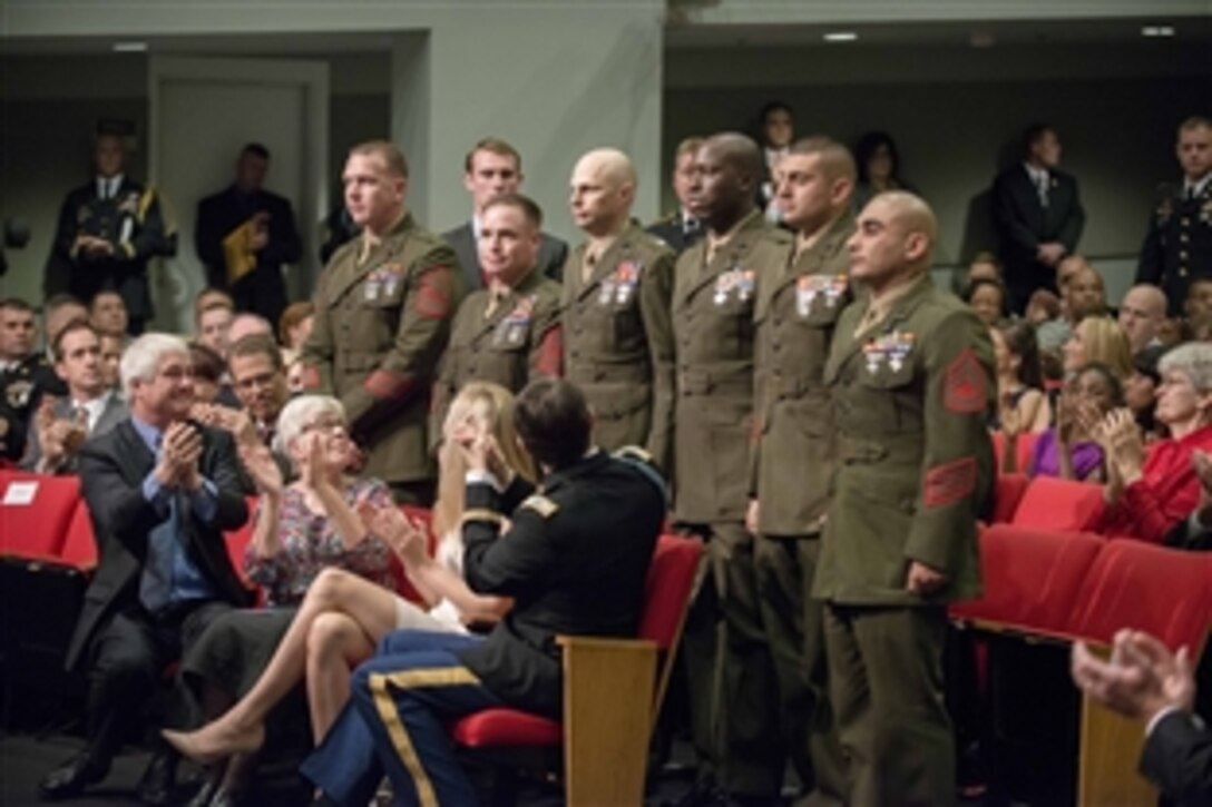 Medal of Honor recipient former Army Capt. William D. Swenson, facing back, applauds Marines with whom he served during the ceremony to induct him into the Hall of Heroes at the Pentagon, Oct. 16, 2013.