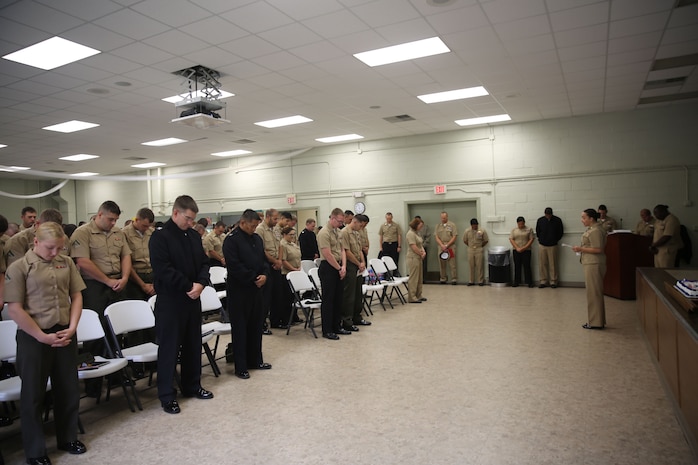 Navy Lt. Regina Johnson, the chaplain for 2nd Medical Battalion, Combat Logistics Regiment 25, 2nd Marine Logistics Group leads Marines and sailors in prayer during a ceremony aboard Camp Lejeune, N.C., Oct. 11, 2013. The ceremony covered a broad array of topics, ranging from Halloween safety to Hispanic Heritage Month. (U.S. Marine Corps photo by Lance Cpl. Shawn Valosin)