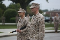 Master Chief Petty Officer Russell W. Folley (left), the senior enlisted sailor for 2nd Marine Logistics Group relinquishes charge to Master Chief Petty Officer Christopher M. Cain (right), during a ceremony aboard Camp Lejeune, N.C., Oct. 16, 2013. During the change of charge ceremony, Folley passed a naval cutlass to Cain as a symbol of passing all responsibilities as the 2nd MLG command master chief. (U.S. Marine Corps still photo by Cpl. Jessica S. Gonzalez)