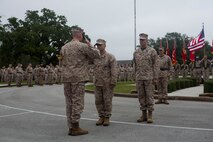 Brig. Gen. Edward D. Banta (left), the commanding general of 2nd Marine Logistics Group, returns a salute to Master Chief Petty Officer Russell W. Folley (center) during a change of charge ceremony aboard Camp Lejeune, N.C., Oct. 16, 2013. Folley relinquished charge to Master Chief Petty Officer Christopher M. Cain (right). (U.S. Marine Corps photo by Corporal William M. Kresse / Released)