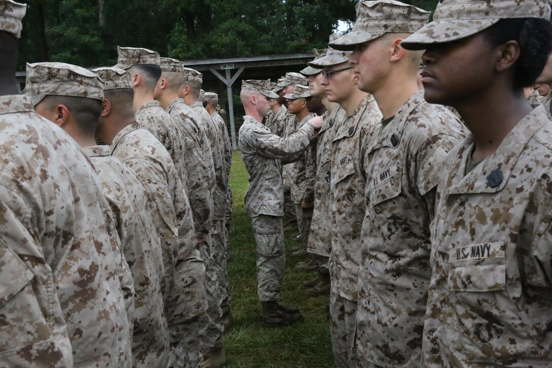 Sailors with the Field Medical Training Battalion receive their shields after an eight-mile hike aboard Camp Johnson, Oct. 8. “Today is a very proud day for the sailors,” said Senior Chief Petty Officer Kinkela Kuedituka, the command senior chief petty officer for the FTMB. “Not only did they complete the eight-mile hike, but they also received their shield, which tells them they can now operate with any Marine Corps unit as far as being a corpsmen or religious program specialist.”


