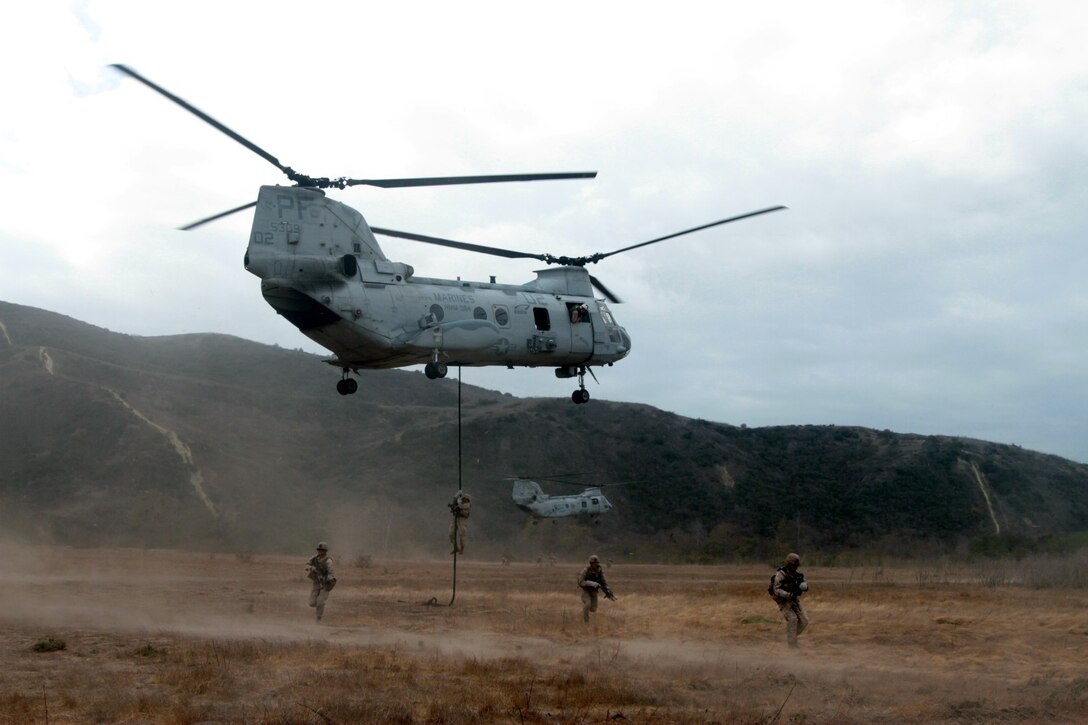 MARINE CORPS BASE CAMP PENDLETON, Calif. – Marines with Kilo Company, 3rd Battalion, 5th Marine Regiment, fast rope from a CH-46 Sea Knight helicopter and secure an objective area during a training exercise here, Oct. 9, 2013. When fast roping, Marines deploy a heavy rope from the rear and center of the helicopter and use their arms and legs to control their descent. Once on the ground, Marines swiftly spread out and secure the area until all Marines unload. Fast roping enables a company of Marines to quickly insert into hostile or inaccessible terrain.