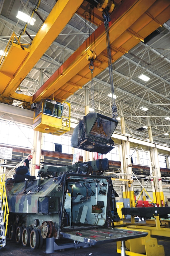 A worker watches as a crane operator removes the plenum from the top of an amphibious assault vehicle during a disassembly process, Oct. 8 at Marine Depot Maintenance Command. The AAV is being repaired and restored like new following its use in combat. There are several stages of the repair process and it will be returned to the Marine Corps’ operating forces once the process is completed. Before workers began disassembling the AAV, others conducted the first stage of the repair process, a limited technical inspection on it.