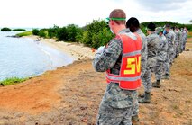 Members of the search and recovery team move one step forward at a time during recent training exercise, held on Sept. 26 on Hickam Beach. The purpose of the search and recovery team is to respond to military-related incidents on base, including military vehicle, aircraft mishap and mass casualty incidents, if and when they occur. (U.S. Air Force photo by Senior Airman Christopher Stoltz)