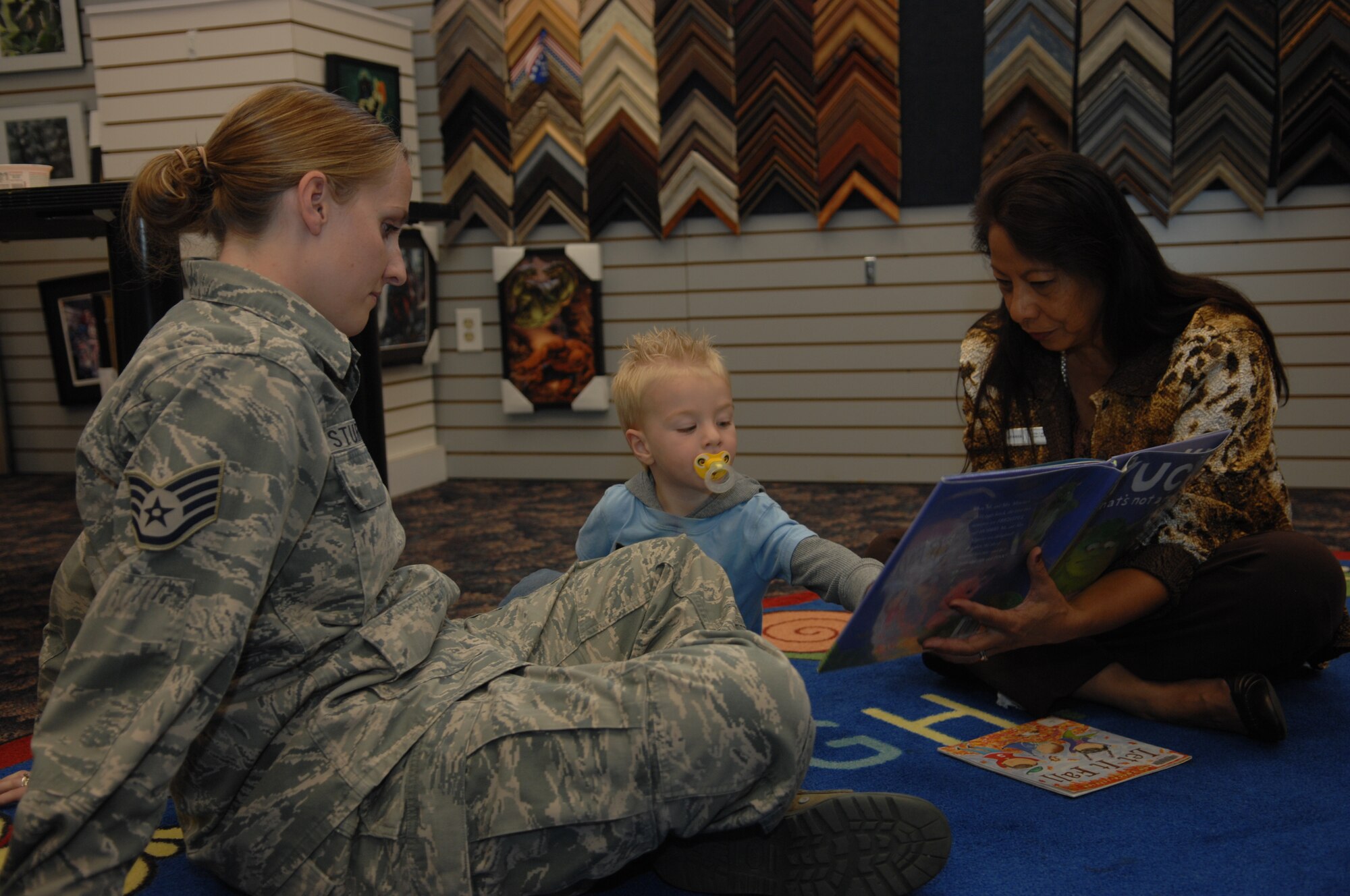Staff Sgt. Maura Sturgeon’s, 355th Force Support Squadron team lead for the First Term Airman Center, son Nathan points to a picture during Reading and Crafting hour at Davis-Monthan Air Force Base, Ariz. Oct. 16, 2013. The hour consisted of a book being read to the children in attendance and then creating jack-o-lanterns with foam designs. (U.S. Air Force photo by Airman 1st Class Betty R. Chevalier)  