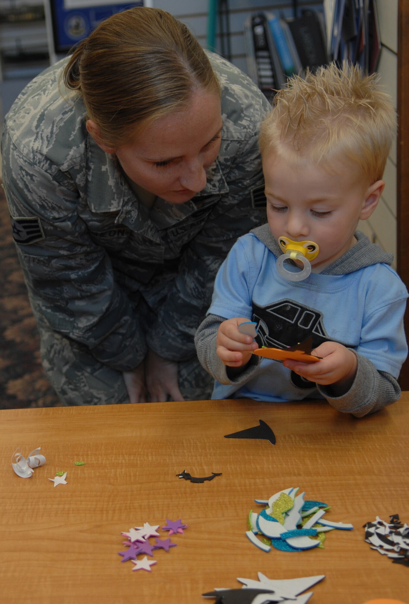 Staff Sgt. Maura Sturgeon, 355th Force Support Squadron team lead for the First Term Airman Center, watches her son create a jack-o-lantern at the Davis-Monthan Air Force Base, Ariz. Arts & Crafts Center, Oct. 16, 2013. The center holds a Reading and Crafting hour that was formerly hosted by the base library. (U.S. Air Force photo by Airman 1st Class Betty R. Chevalier)  