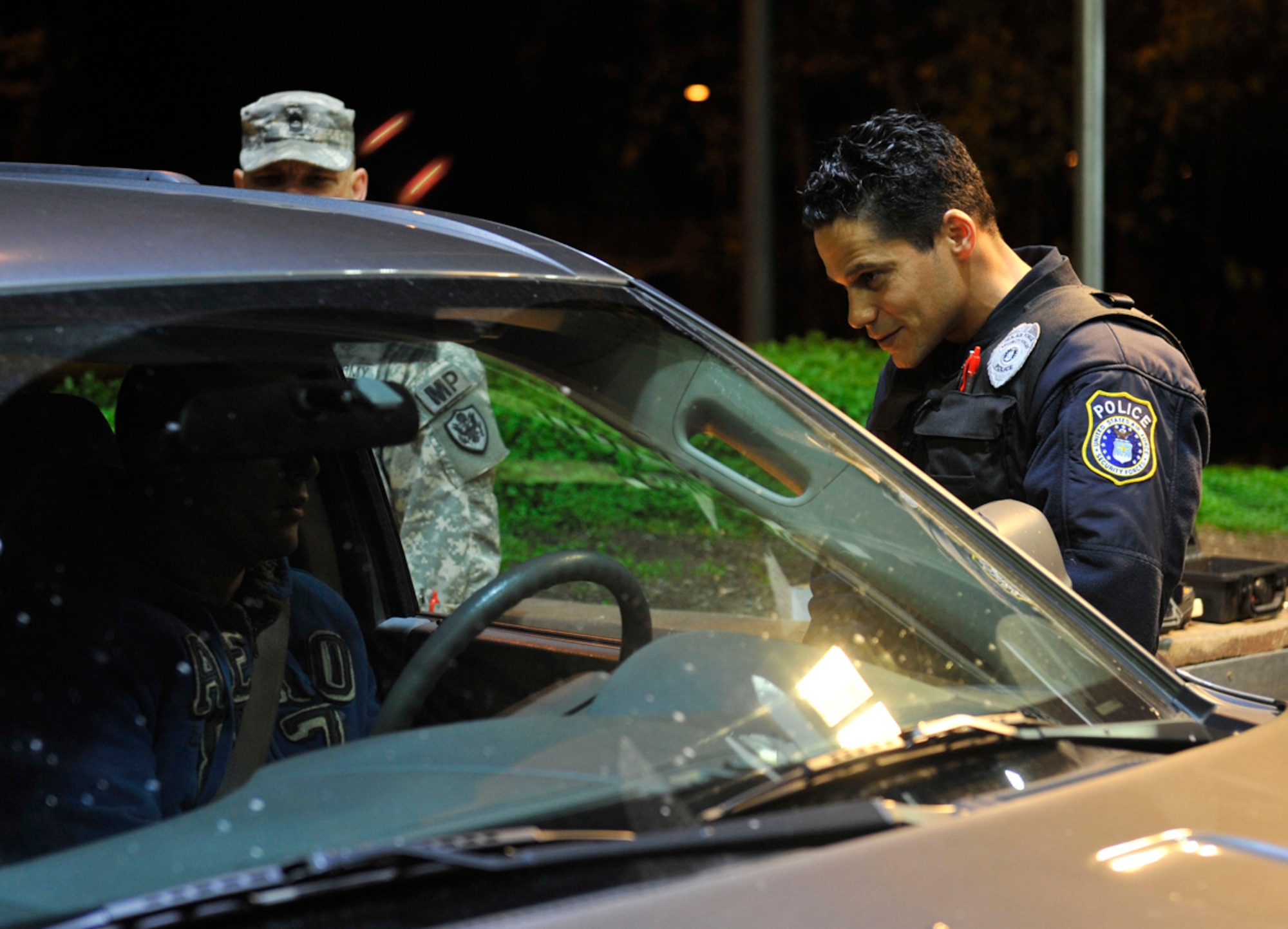 Edwin Hernandez Jr., Joint Base Elmendorf-Richardson civilian police officer, talks with a driver during Operation Nighthawk on JBER, Oct. 12. The operation was a random driving-under-the-influence checkpoint the 673d Security Forces Squadron set up to administer preliminary breathalyzer tests to all driving military members or to civilians who showed signs of being intoxicated. The purpose of the checkpoint was to deter military members from drinking and driving. (U.S. Air Force photo/Airman 1st Class Tammie Ramsouer)
