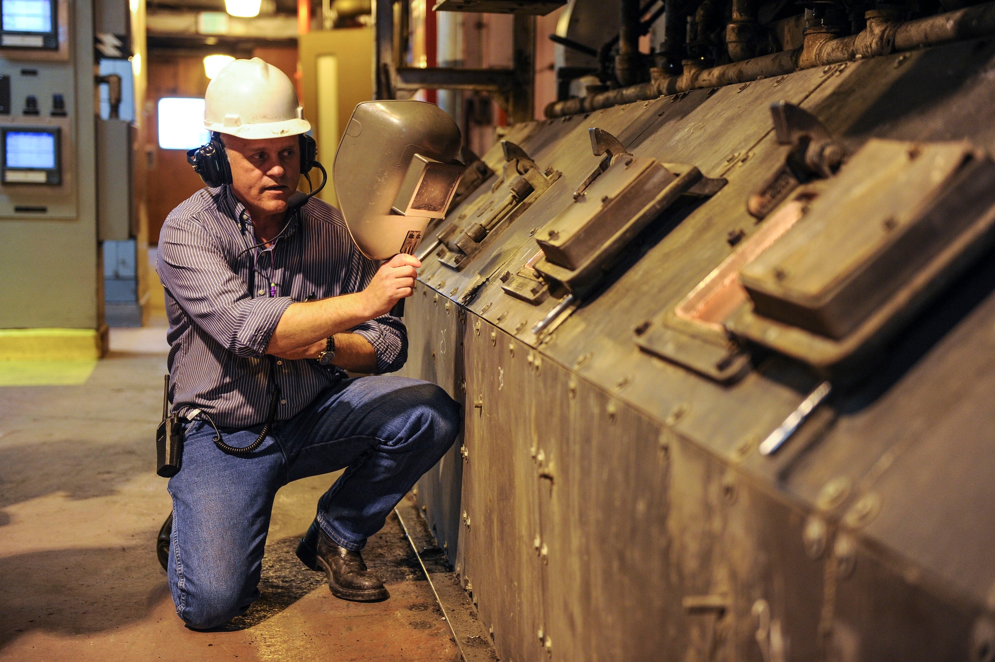 Marty Overlin, 354th Civil Engineer Squadron central heat and power superintendent, describes what happens in the front side of a boiler to 354th Fighter Wing commanders during a tour of the central heat and power plant Oct. 15, 2013, Eielson Air Force Base, Alaska. The front side of the boiler is where ash is dumped off the traveling grate and dropped into an ash hopper. The ash is then pneumatically conveyed to silos for disposal. (U.S. Air Force photo by Senior Airman Joshua Turner/Released)